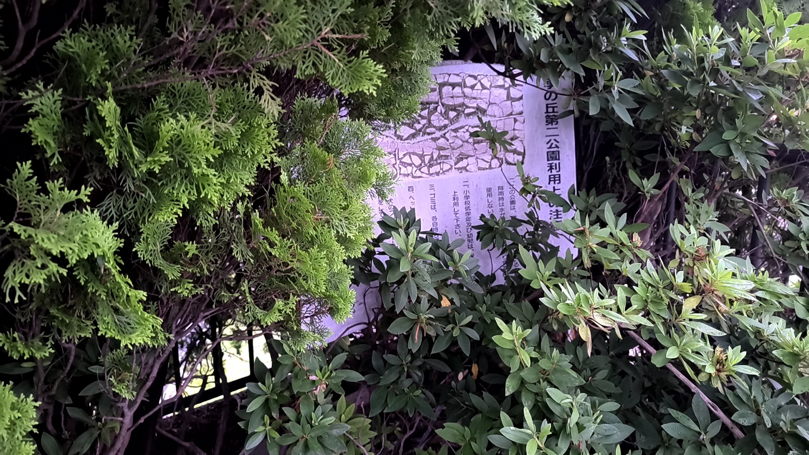 植栽に一部隠れた四季の丘第二公園の利用案内板