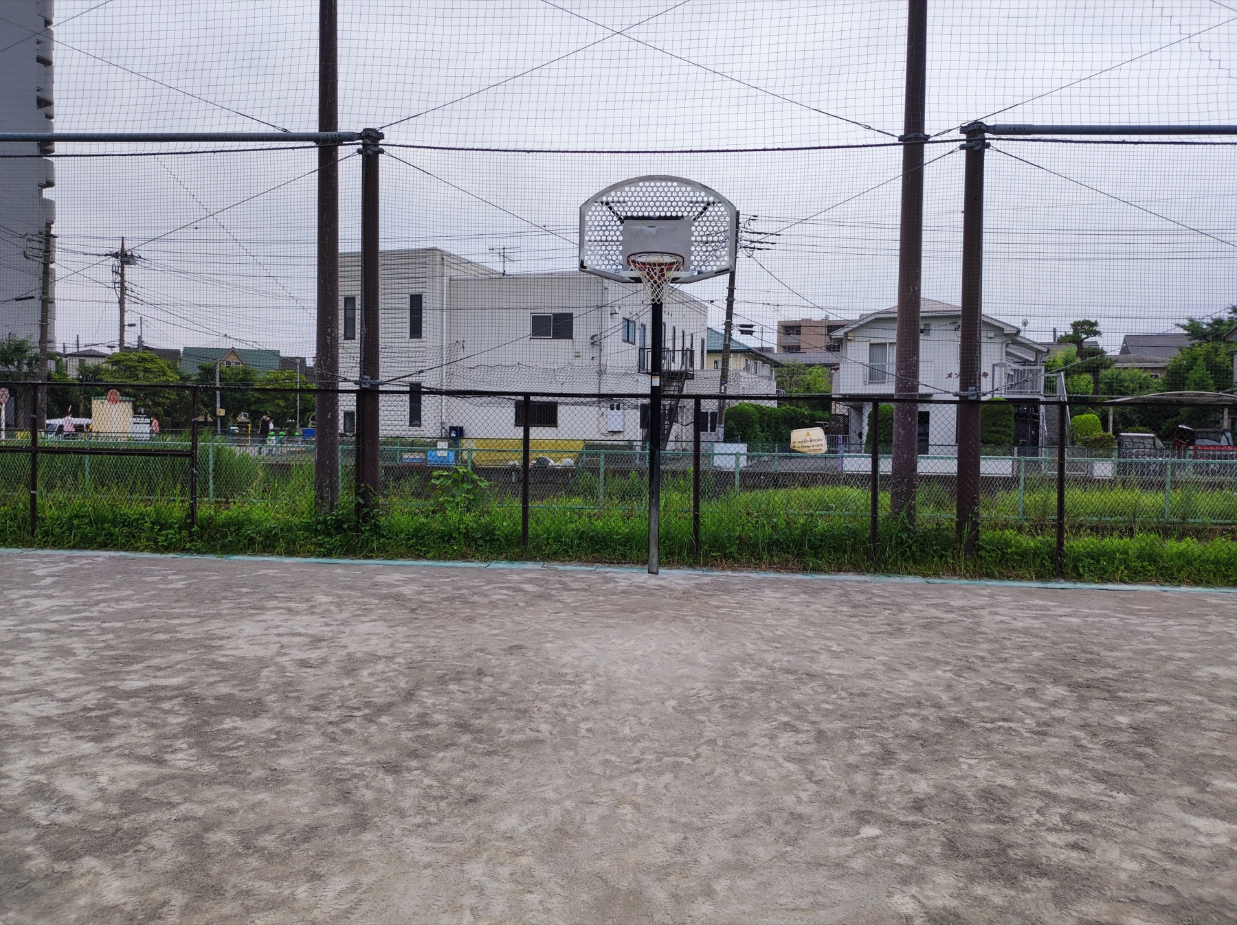 正面から見たとちのき広場のバスケットゴールと土の地面
