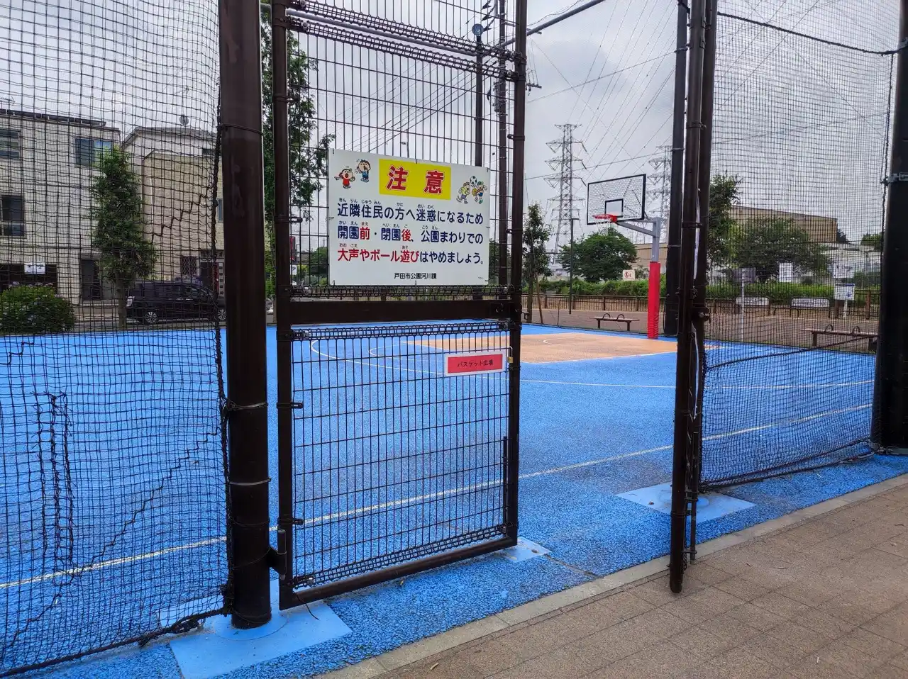 ボール公園のバスケットコート入口と近隣への配慮を呼びかける看板